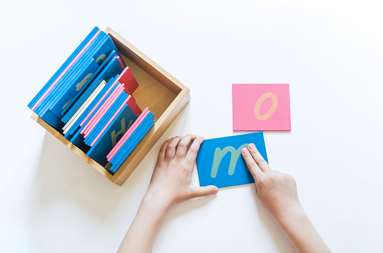 A student using sandpaper letters as part of a Montessori lesson plan. 
